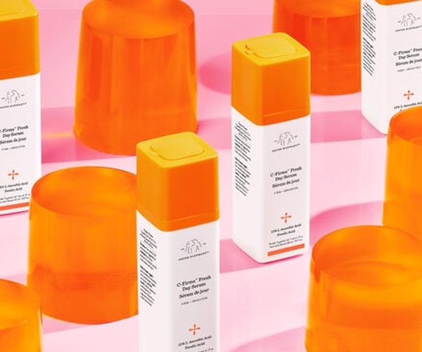 Image of C-Firma Fresh bottles standing next to orange props against a pink background ad image